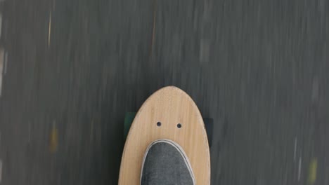 close-up top pov shot of a skater playing skateboard or cruiser board on asphalt