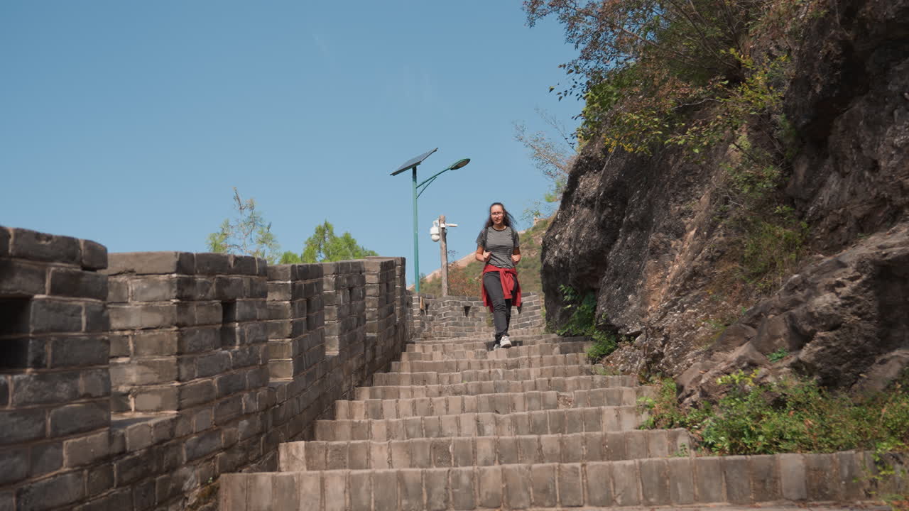 Du khách khám phá ngoài trời. Người leo núi đang xuống cầu thang núi gồ ghề dưới bầu trời trong xanh. Người đi bộ đường dài cẩn thận xuống cầu thang đá không bằng phẳng dưới bầu trời xanh sáng trong chuyến phiêu lưu ngoài trời.