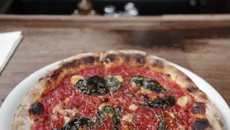 cooked marinara pizza on a plate inside pizzeria bianco in phoenix, arizona with video tilting down