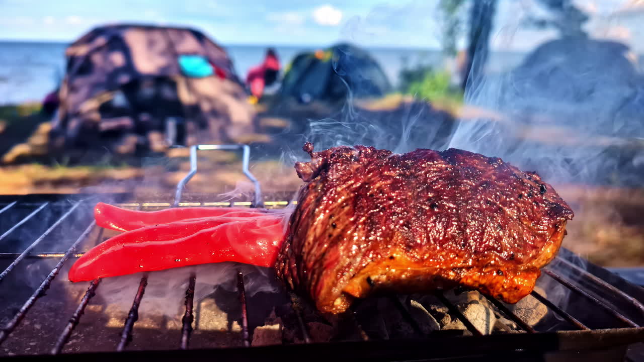 A POV shot tilts down from a view of tents at a seaside campsite on the Baltic Sea to a close-up of a juicy steak and chili pepper sizzling on a hot charcoal grill in Latvia