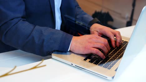 Businessman-using-laptop-in-cafÃ©