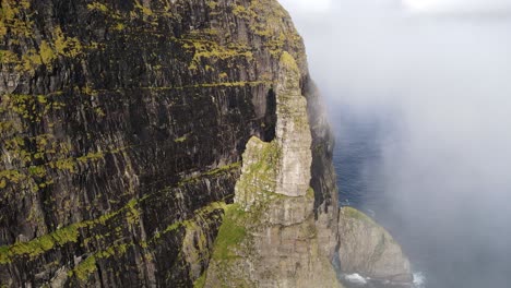 Circular-drone-footage-of-the-Witch-Finger-in-the-clouds-at-Sandavagur-on-the-Vagar-island-in-the-Faroe-Islands