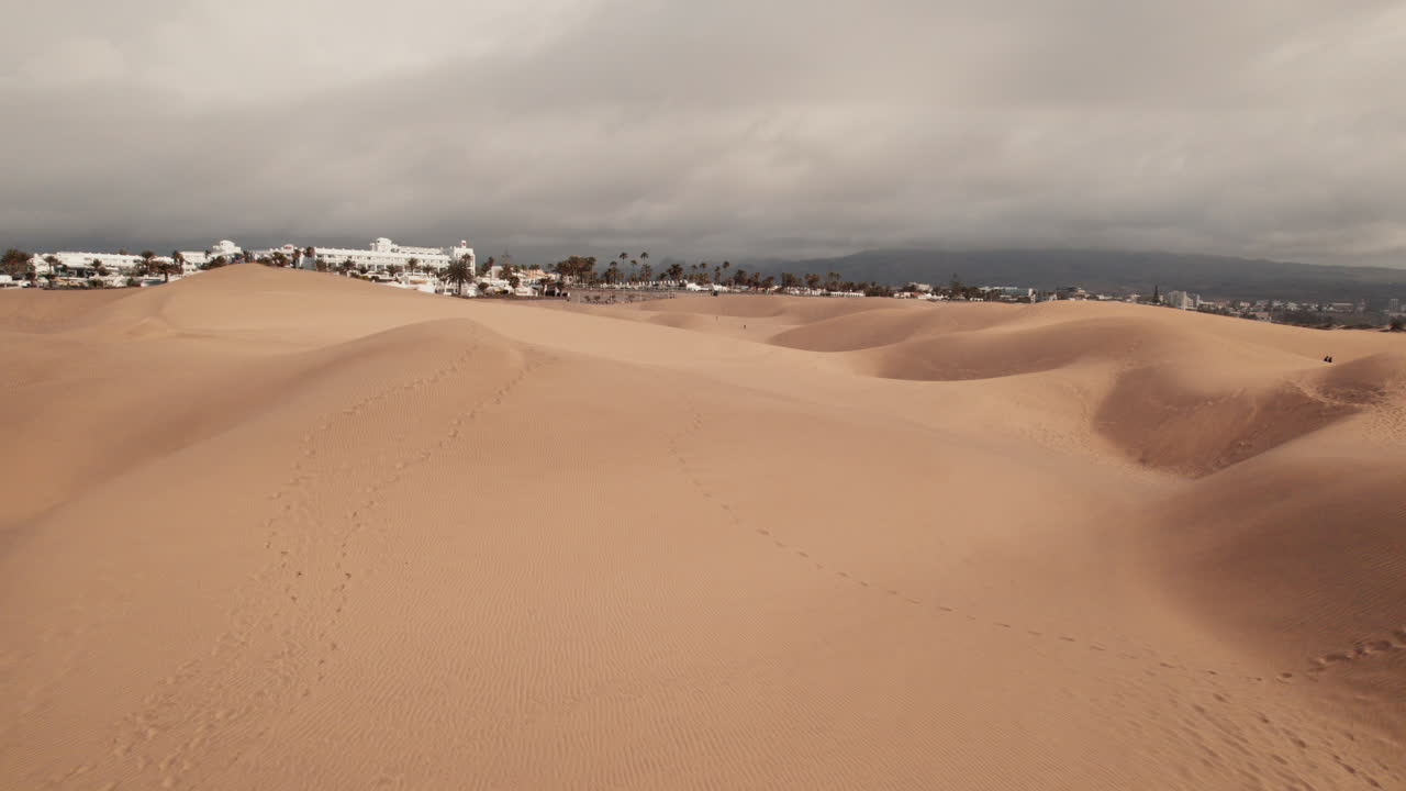 vuelo bajo de drones sobre las dunas de maspalomas barridas por el viento en gran canaria