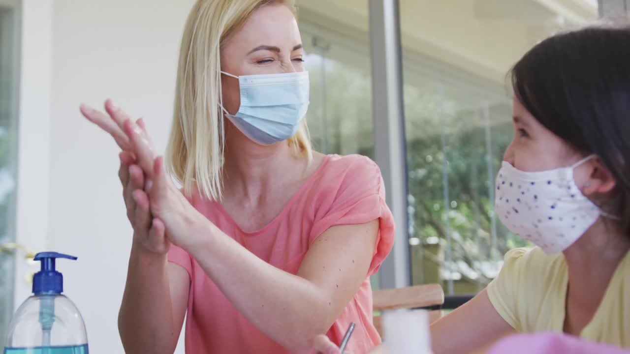 mujer con máscara facial desinfectando sus manos en casa