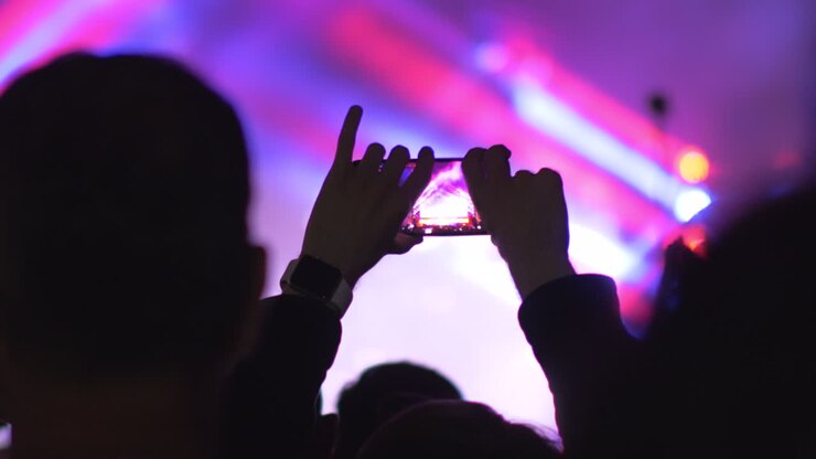Fare un video con il cellulare di una performance di concerto.