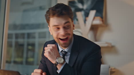 Successful manager rejoicing win looking laptop screen in evening office closeup