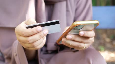 Women-hand-holding-credit-card-and-using-smart-phone-shopping-online