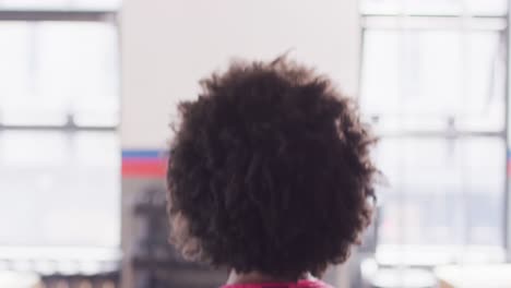 Video-of-rear-view-of-african-american-woman-working-out-at-a-gym-doing-kettlebell-swings