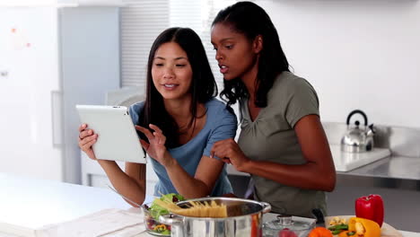 Mujeres-Jóvenes-Siguiendo-Recetas-En-Línea-En-Una-Tableta-