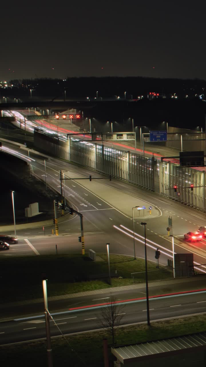 Timelapse pan shot showing traffic flow on illuminated city roads and highways at night