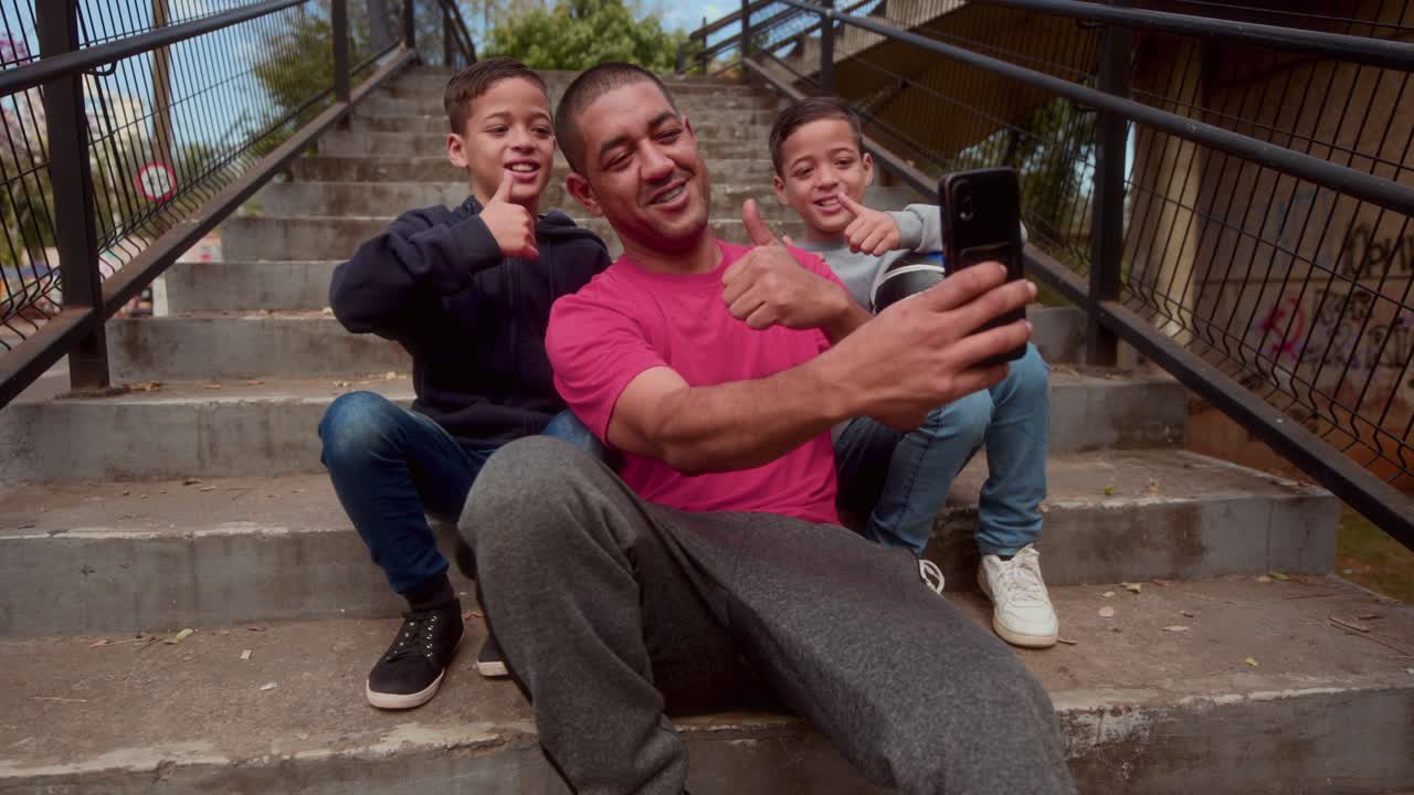 Padre e figli che si scattano un selfie sulle scale