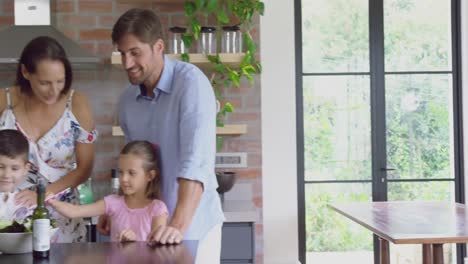 Family-preparing-food-together-at-table-in-kitchen-at-home-4k