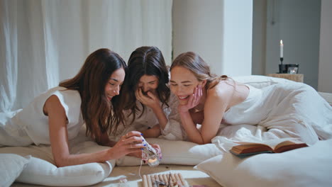 attractive girls burning wooden sticks in spa room. best friends laughing rest