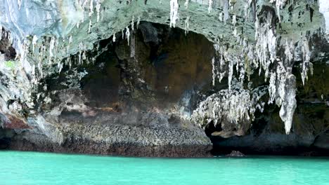 cave with stalagmites above clear turquoise water