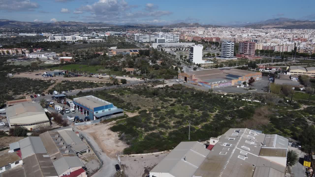 Volando sopra vecchie fabbriche abbandonate verso la città di Elche, Spagna.