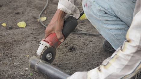 chispas de luz cuando un trabajador está cortando un tubo de metal usando una molienda