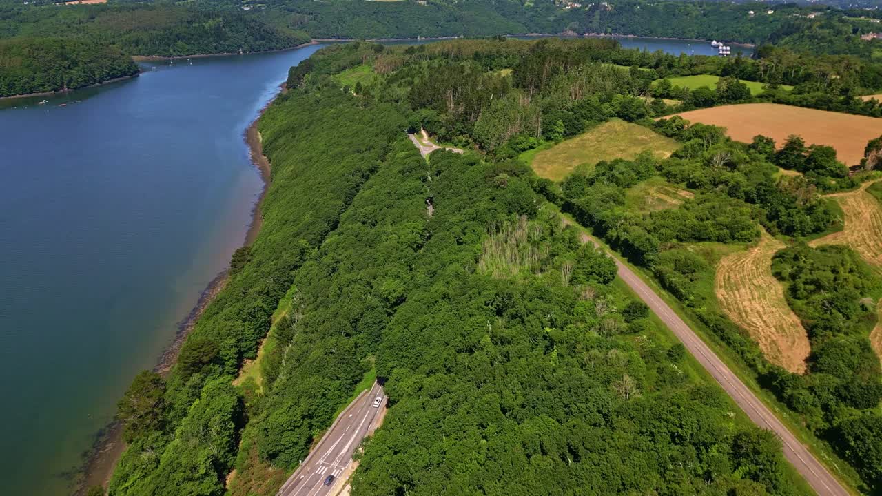 Drone captures river, roads, hills, and vegetation near Belvédère de Térénez in Brittany. France
