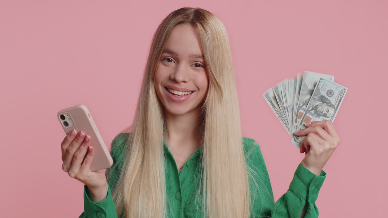 Happy woman looking smartphone display rejoicing win celebrating receiving money dollar cash jackpot