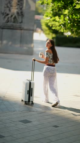 woman walking with suitcase in city