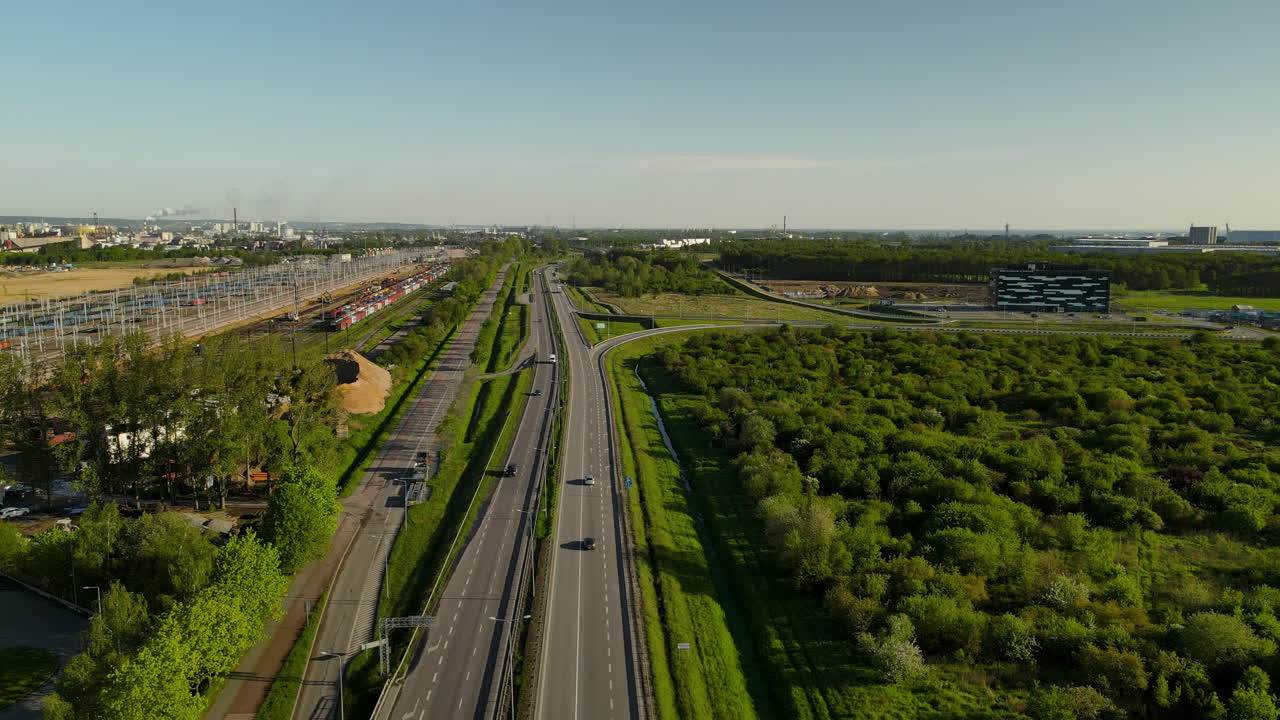 폴란드 그단스크에서 낮에 들판에 울창한 초목이 있는 도로에서 운전하는 자동차