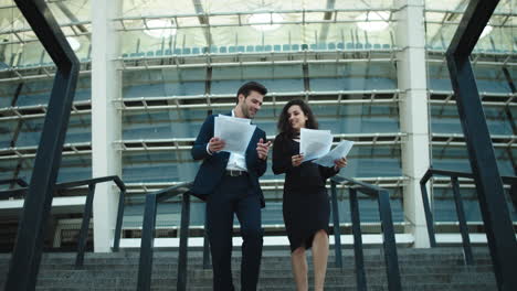 Couple-walking-stairs-in-formal-clothing.-Couple-throwing-papers-in-slow-motion