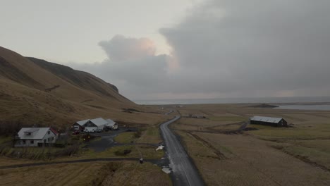 Imágenes-De-Drones-De-Una-Carretera-Costera-Islandesa-Con-Algunas-Casas