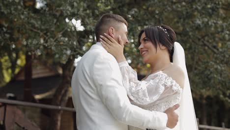 recién casados, novio caucásico con la novia caminando, abrazándose, abrazándose en el parque, pareja de bodas enamoradas