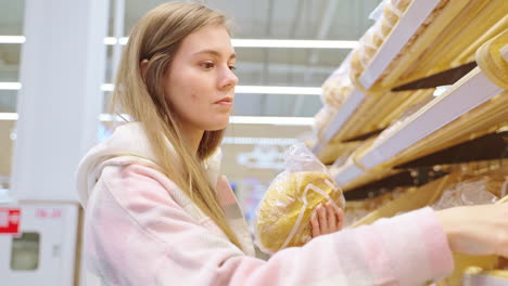 mujer comprando pan en un supermercado