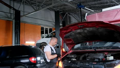 mechanic inspecting a car engine in a repair shop