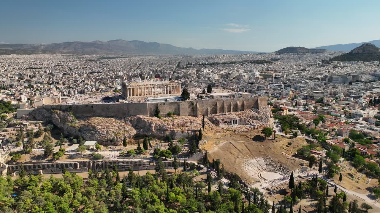 Drone footage of Athens Acropolis, Parthenon and surrounding ancient theaters in full daylight, revealing the city's historic heart and urban sprawl.