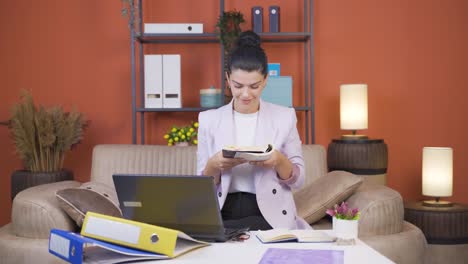 trabajadora de oficina en casa, mujer joven leyendo un libro.