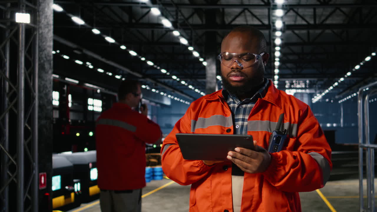 Black professional technician checking workshop equipment in a warehouse