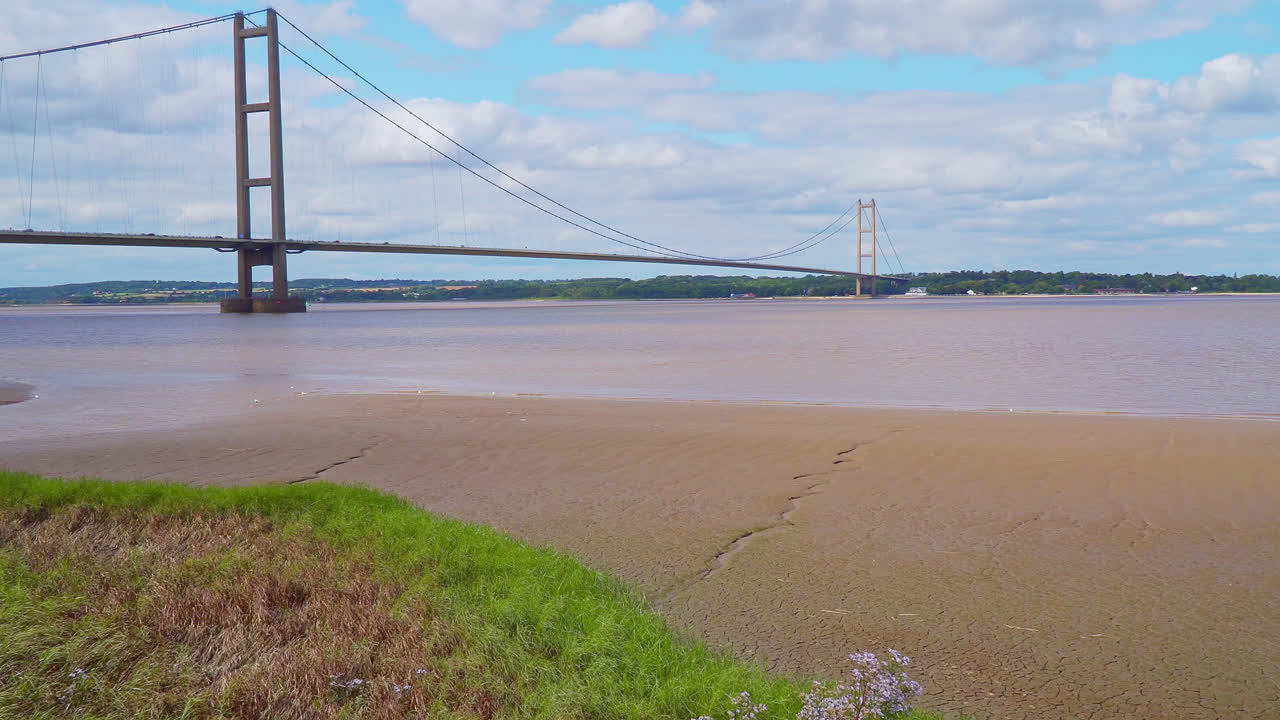 공중 드론 비디오는 험버 다리를 보여줍니다. 세계에서 12번째로 큰 서스펜션 스 ⁇ 으로, 험버 강을 가로질러 링컨셔와 험버 사이드를 교통으로 연결합니다.