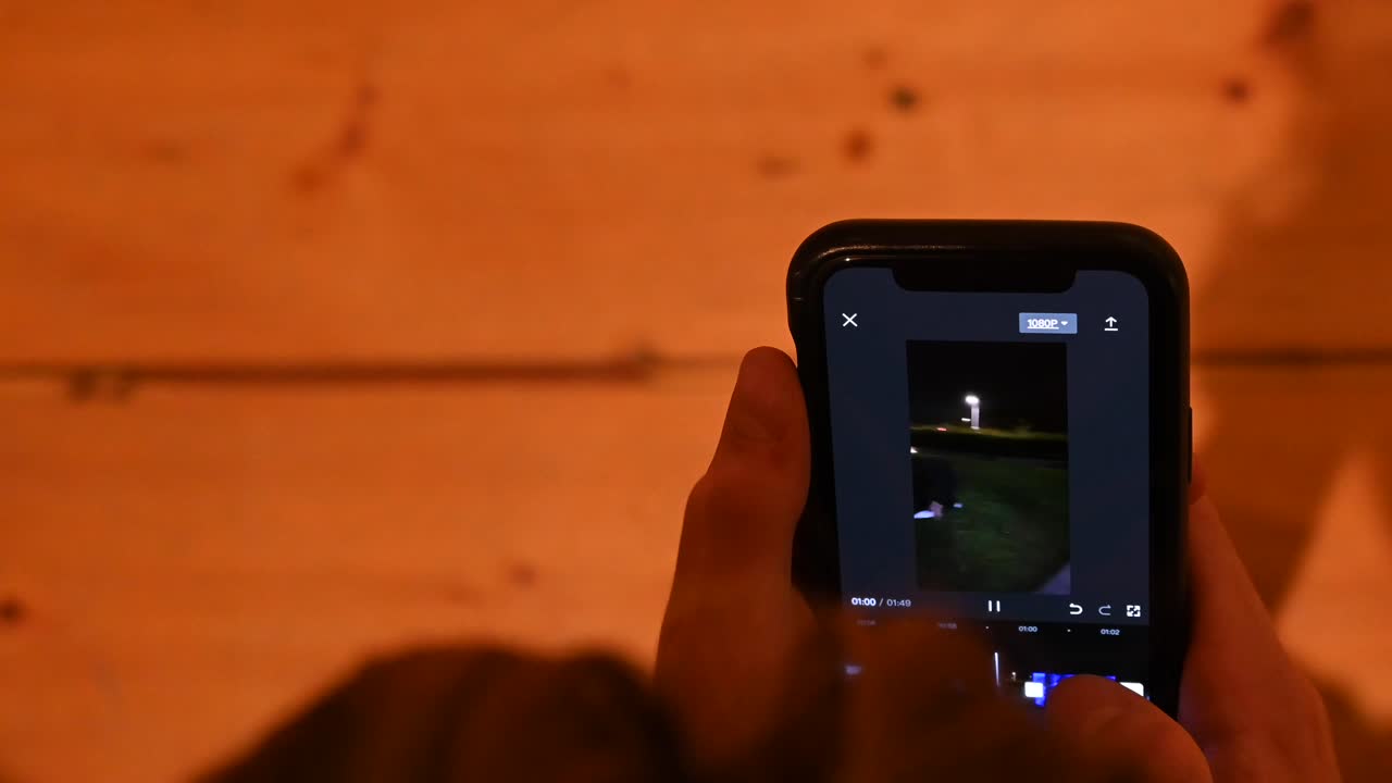 vista por encima del hombro: un joven está usando su teléfono, perdiendo el tiempo detrás de su teléfono