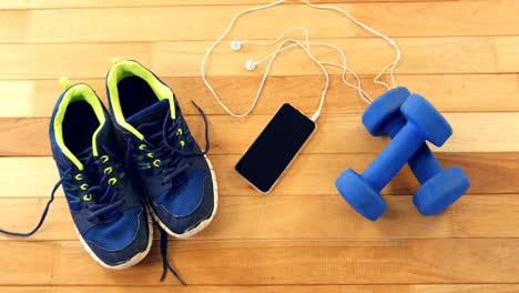 mobile phone with headphones, shoes and dumbbells