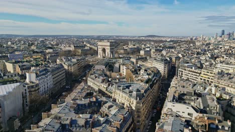 Drone-flying-over-roofs-of-Paris-with-Triumphal-arch-or-Arc-de-Triomphe-in-background,-France