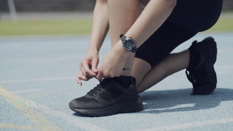 an unrecognizable female athlete tying her laces