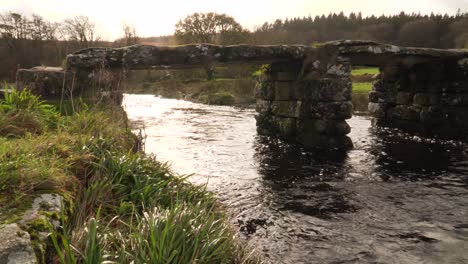 view of bridges of rough stone in the middle of the national park in the english country side with a stream under it