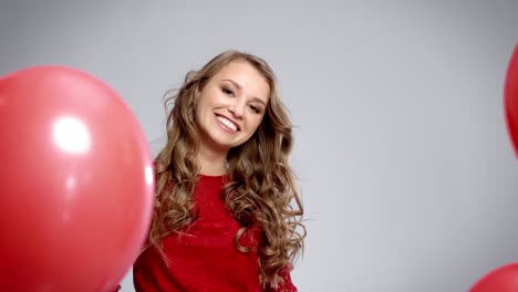 happy woman among red balloons