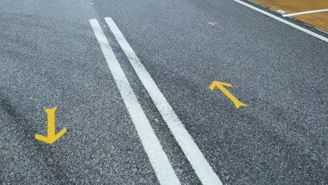 Macro-Of-Yellow-Arrow-Road-Markings-At-The-Cemented-Highway