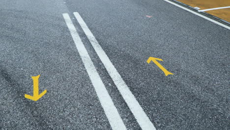 macro of yellow arrow road markings at the cemented highway