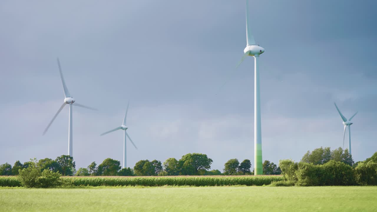거대한 회전하는 풍력 터빈이 푸른 풍경 속에서