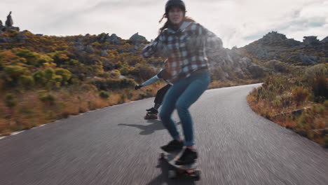 Joven-Mujer-Feliz-Montando-Longboard-Amigos-Patinando-Disfrutando-De-Un-Crucero-Cuesta-Abajo-En-Una-Hermosa-Carretera-Rural-Divirtiéndose-Usando-Patineta-Usando-Casco-Protector