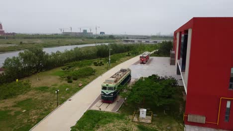 Aerial-front-view-of-two-exposed-locomotive-vintage-trains-at-Beijing-Jiaotong-University-Weihai-campus,-China