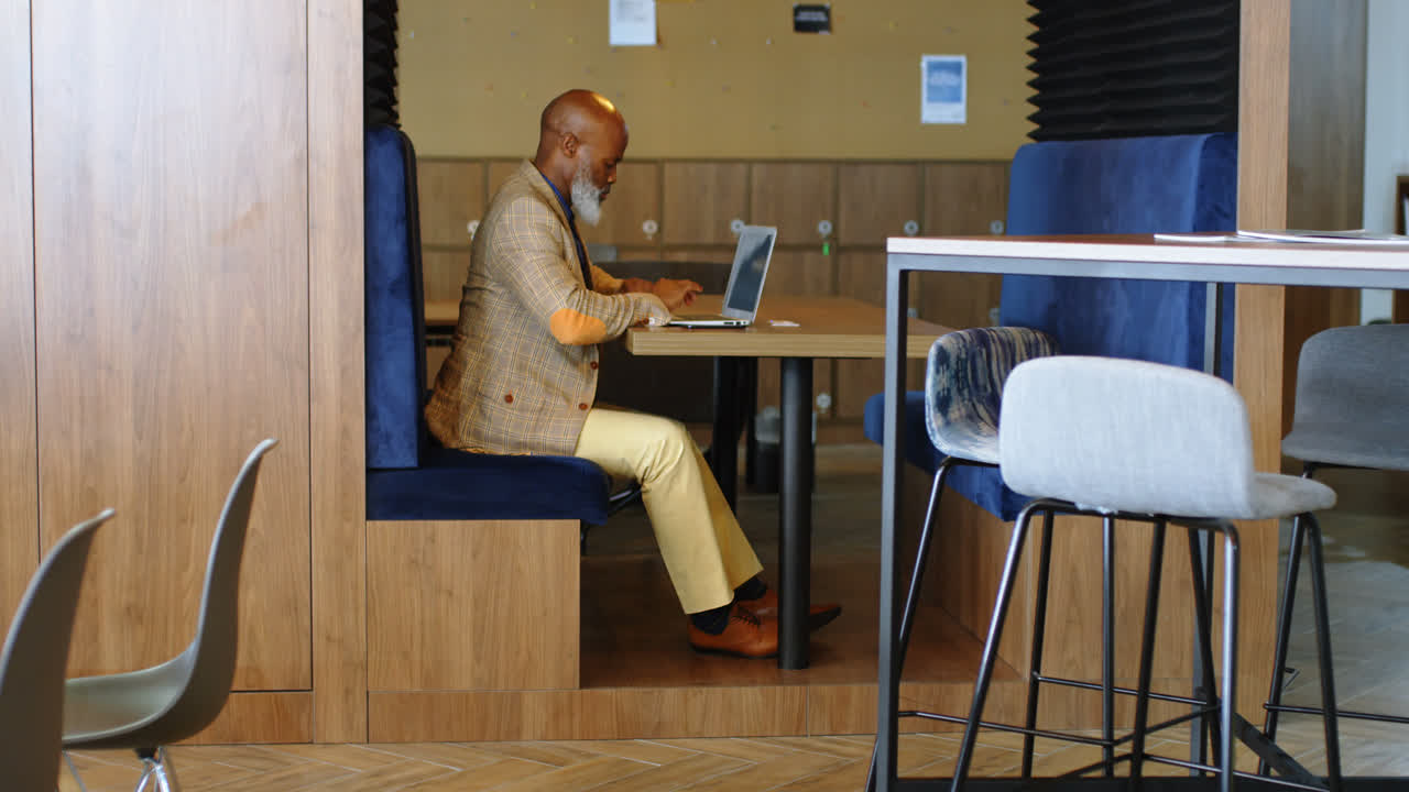 hombre mayor usando una computadora portátil 4k