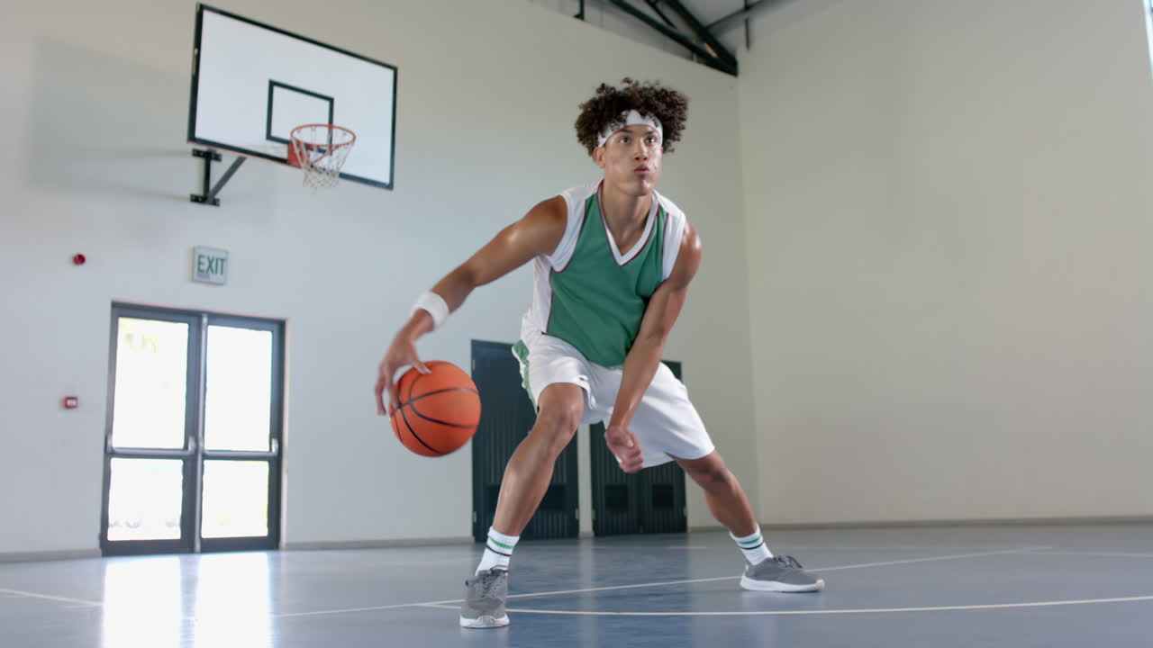joven biracial juega al baloncesto en el interior
