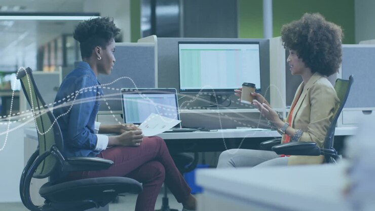 Two colleagues discussing work at office with data processing animation overlay