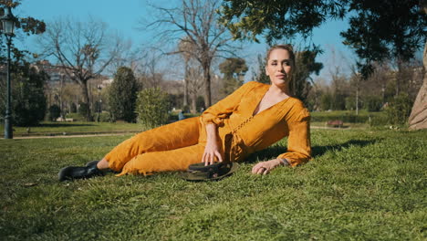 stylish young woman lying on the grass outdoors.