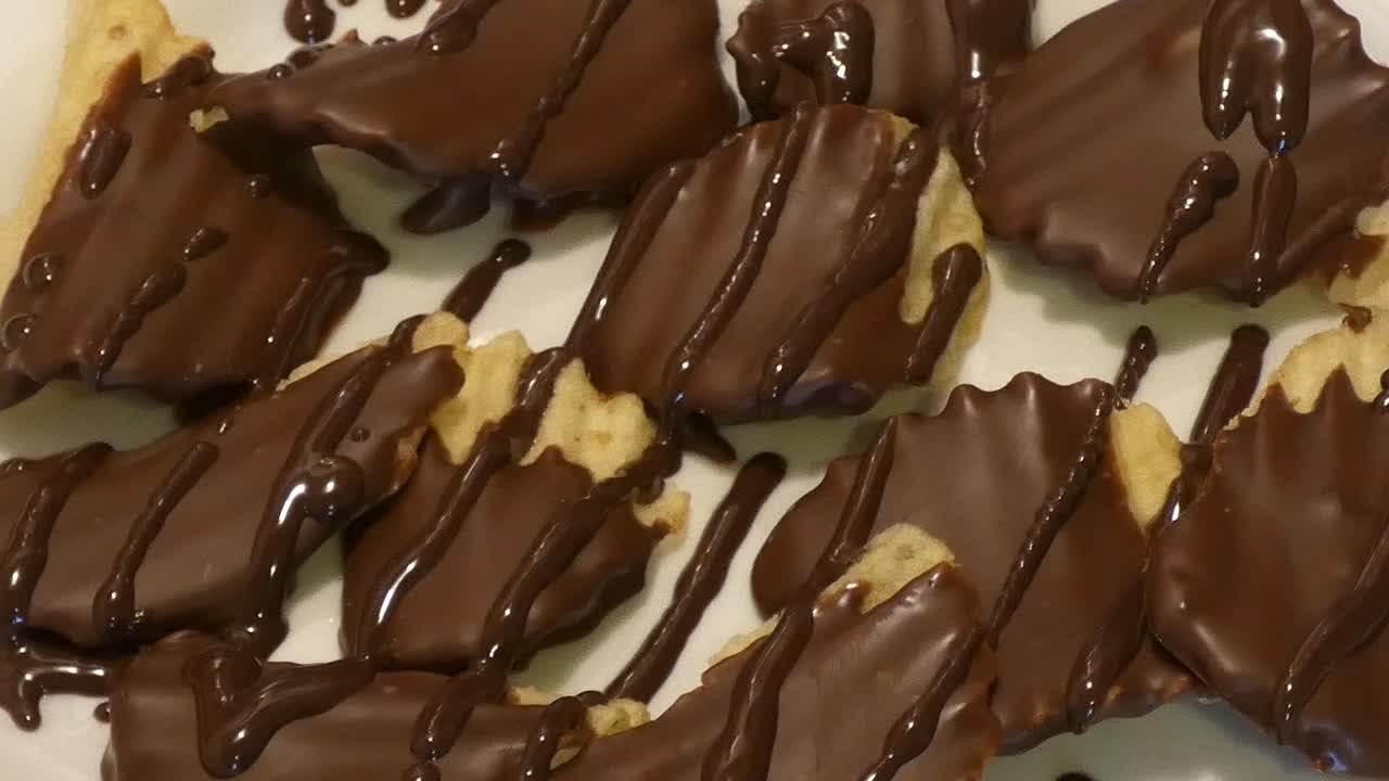 Slow pan over a plate of chocolate-covered potato chips drizzled with dark chocolate.
