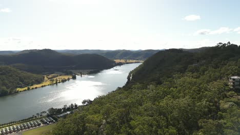 Aerial-pan---North-to-South---from-a-drone-at-Hawkins-Lookout,-Wisemans-Ferry,-New-South-Wales,-Australia,-showing-the-majestic-Hawkesbury-River-and-the-Blue-Mountains-in-the-distance